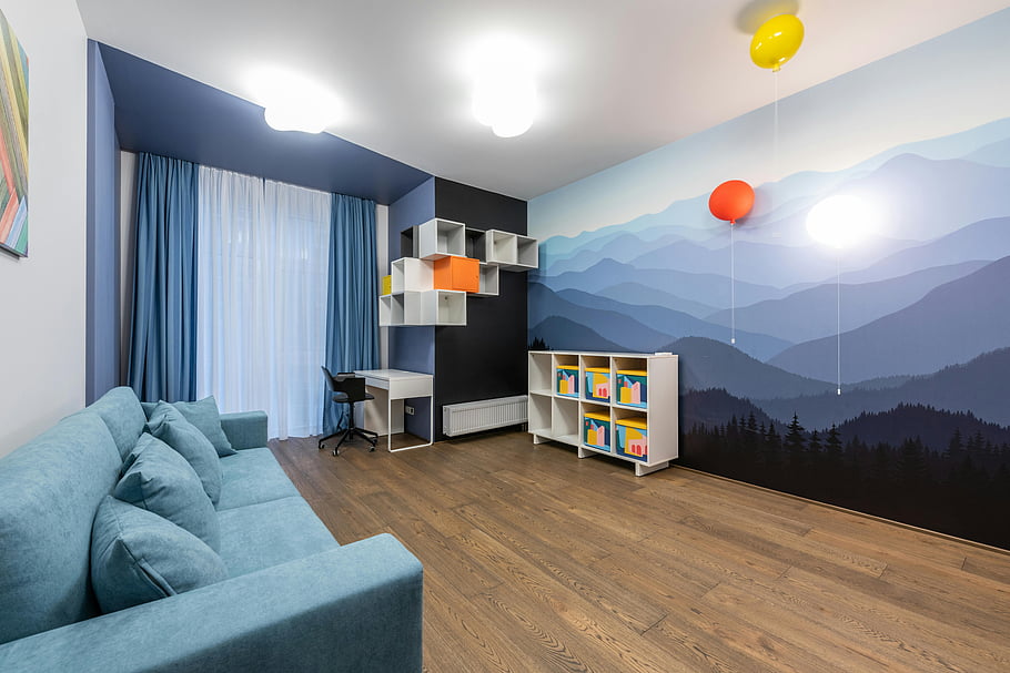 contemporary interior, spacious room, blue sofa, creative shelving, mountain mural, wall art, balloons, modern room, wooden floor, colorful decor, cozy living space