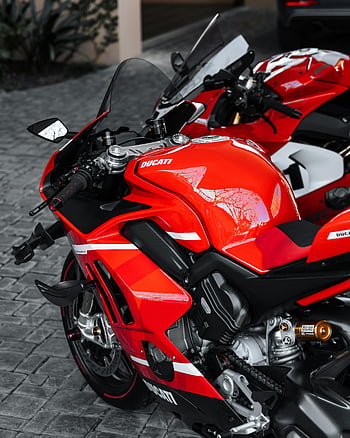 moto rossa, ducati, strada di ciottoli, rosso vivace, design elegante, velocità, moto parcheggiata, motociclo, scena di strada, ambientazione esterna, bici sportiva