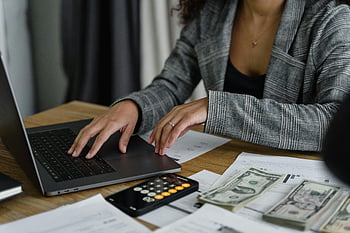 Femme en blazer à carreaux, portable, gestion des finances, en espèces, calculatrice, bureau, femme d'affaires, travail, documents, réglage du bureau, tenue professionnelle