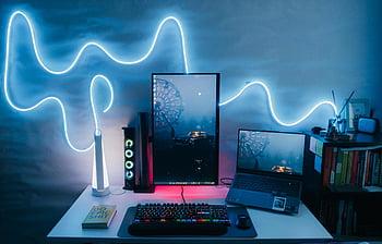 modern desk setup, vertical monitor, laptop, neon light, contemporary desk, LED light decoration, stylish desk, computer setup, home office, tech workspace, ambient lighting