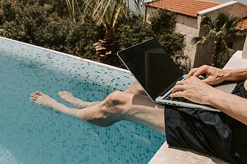 ember dolgozó laptop, úszómedence, nyári környezet, fekete laptop, medence melletti munka, szabadtéri munka, nyugodt munka, medence melletti pihenés, nyári munka, medence melletti laptop, ember a medencével