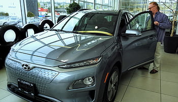 ヒュンダイコナエレクトリック、 Kona EV、 ブリティッシュコロンビア、 カーディーラー、 電気自動車、 新車、 車を点検する男性、 車内、 車の外観、 車のタイヤ、 自動車ショールーム