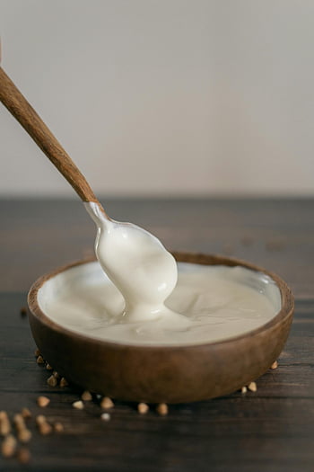 wooden bowl, sour cream, wooden spoon, rustic wooden bowl, creamy sour cream, table, food photography, dairy product, rustic tableware, wooden table, spoonful of sour cream