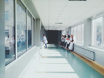 Nemocniční chodba, zdravotnický personál, bílé kabáty, Profesionální zdravotní péče, skleněná okna, jasně osvětlené, vnitřní prostředí, Zdravotníci, lékaři, nemocniční chodbě, Nastavení zdravotní péče