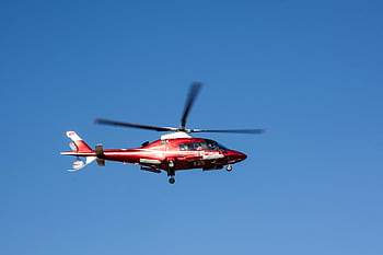 red helicopter, flying helicopter, emergency medical rescue, clear blue sky, rescue helicopter, medical helicopter, red and white helicopter, aerial rescue, helicopter in flight, emergency services, air ambulance