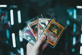 Pokemony karty handlowe, charizard, Karty kolekcjonerskie, trzymanie ręki, tło bokeh, Entuzjaści kart handlowych, Karty pokemonów, zbieranie kart, handel kartą, niewyraźne tło, Entuzjaści kart