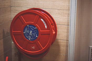red hose storage handle, fire hose reel, wooden wall, indoor safety, red fire hose, hose reel, safety equipment, indoor fire safety, red hose reel, fire safety, wooden wall mounted