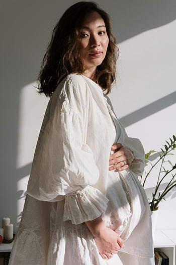 임산부, 하얀 드레스, 아기 범프, 자연광, 실내 사진, 고요한 분위기, 긴 소매 드레스, 부드러운 조명, 임부복 패션, 흰색 긴 소매, 실내 설정