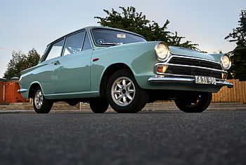 vintage blue car, low-angle view, classic car, parked outdoors, asphalt road, dusk, vintage vehicle, classic automobile, outdoor parking, car photography, vintage automotive