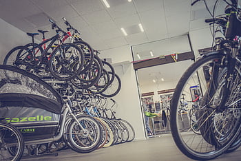 bicycle shop, diverse bicycles, modern shop interior, bike styles, equipment, hanged bicycles, piled bicycles, Gazelle Cabby, shop display, bike variety, interior design