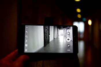 selective focus photography, turned-on Android smartphone, smartphone camera, empty indoor hallway, contemporary architectural setting, hallway photography, indoor photography, smartphone photography, architectural photography, hallway focus, contemporary architecture