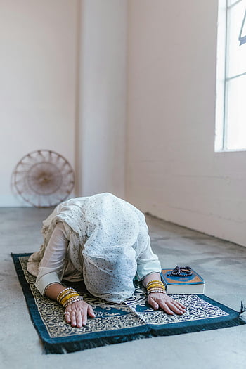 Muslim woman, white hijab, praying, indoors, Quran, prayer beads, traditional attire, prayer mat, spiritual, religious, meditation