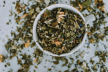 dried herbal tea, overhead shot, white ceramic cup, dried tea leaves, dried flowers, herbal blend, tea cup, dried herbs, tea leaves, white cup, brown ceramic