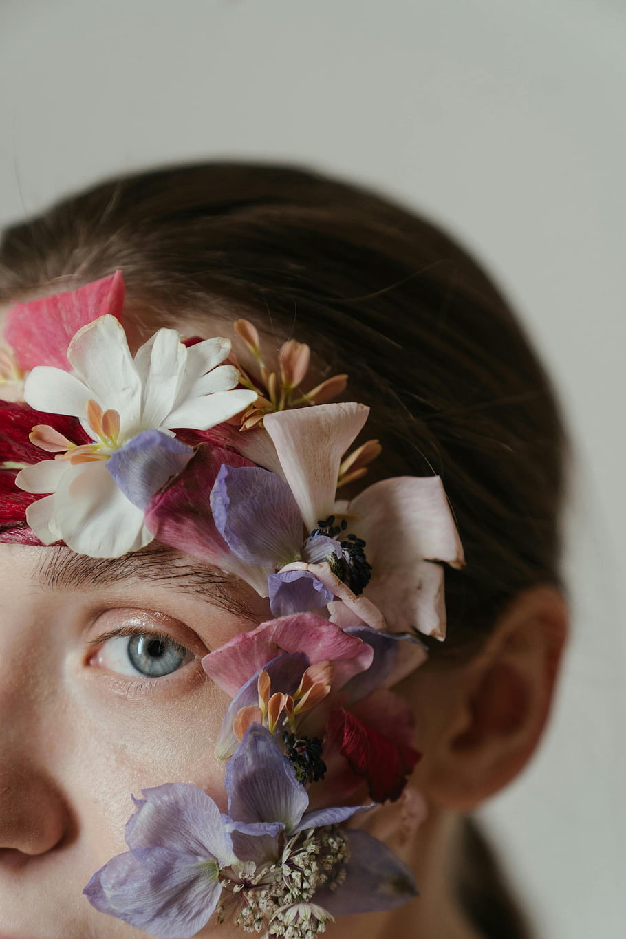 woman with flowers, white and purple flowers, delicate flower petals, young woman portrait, floral headpiece, captivating portrait, floral adornment, woman's eye, floral beauty, artistic portrait, floral fashion
