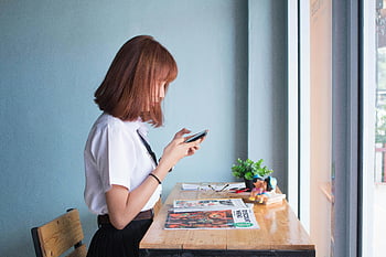 γυναίκα που χρησιμοποιεί smartphone, πλευρικό προφίλ, νέα γυναίκα, κομψό ξύλινο γραφείο, μεγάλο παράθυρο, smartphone, γραφείο, παράθυρο, εσωτερική ρύθμιση, casual ενδυμασία, φυσικό φως