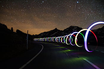 verlichte bermranden, kleurrijke lichte paden, lange blootstelling, bochtige weg, met sterren gevulde lucht, nachtfotografie, berglandschap, betoverende scène, licht schilderij, nachtelijke hemel, Sterrennacht