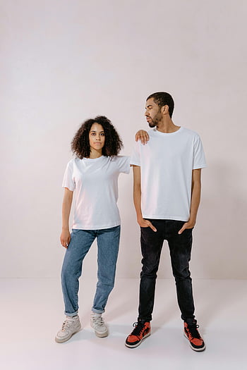 casual outfit, white t-shirt, black denim jeans, blue jeans, young adults, relaxed stance, confident pose, blank t-shirts, studio photo, casual style, sneakers