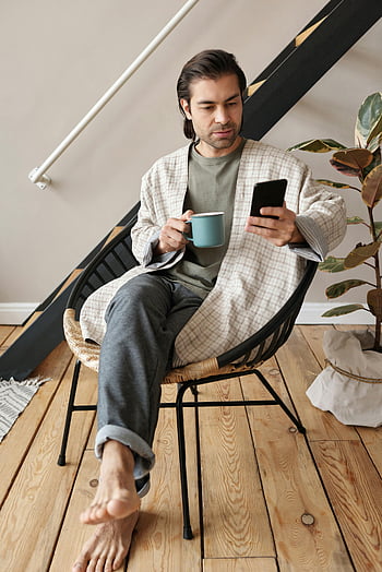 bărbat ședinței, halbă, smartphone, de interior, ținută confortabilă, relaxant, cană de cafea, utilizarea smartphone -ului, cadru casual, podea de lemn, Scaun modern