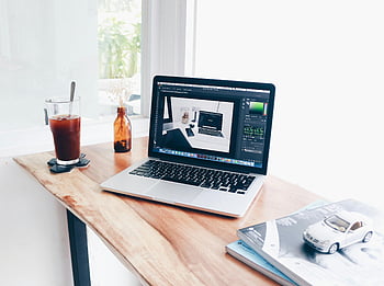 silver macbook pro, brunt träbord, mysig hemmakontor, bärbar dator, iskaffe, träskrivbord, hemmakontoret, skrivbord setup, arbeta hemifrån, kontorsskrivbord, kaffe på skrivbordet