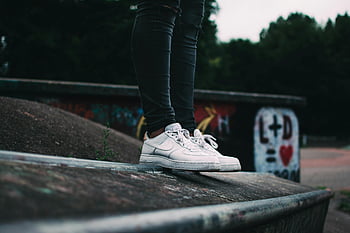 λευκά παπούτσια Nike, φόντο γκράφιτι, υπαίθριο αστικό περιβάλλον, πλάνα πάνινα παπούτσια, λευκά πάνινα παπούτσια, αστικό περιβάλλον, γκράφιτι τοίχο, εξωτερική φωτογραφία, παπούτσια nike, στυλ δρόμου, περιστασιακά υποδήματα