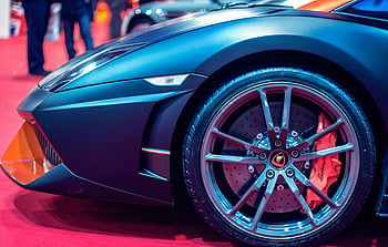 Blue luxury car, sports car wheel, red carpet, auto show, detailed view, luxury sports car, car wheel, red brake calipers, high-end vehicle, car exhibition, auto event