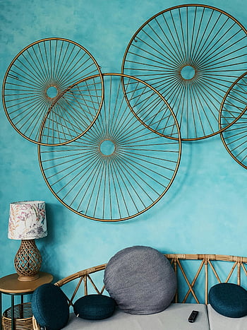 sophisticated living space, artistic wall decor, cozy seating area, circular wall art, blue wall, rattan sofa, decorative pillows, modern interior design, living room decor, lampshade, contemporary furniture