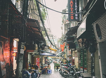 Hanoi alley, motorcycles parked, urban atmosphere, shops, motorbikes, vibrant scene, city life, street view, Vietnamese culture, alleyway, storefronts