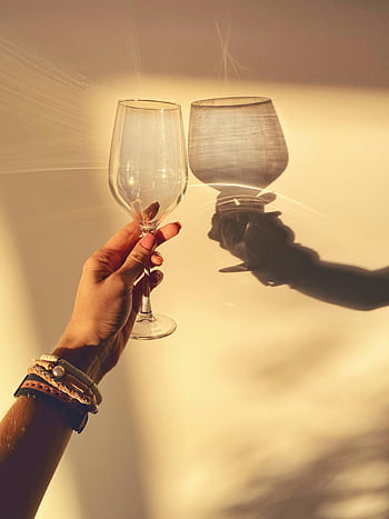 tenendo il bicchiere di vino, ombra sul muro, mano elegante, bracciali, parete illuminata dal sole, vetro luccicante, Casting Shadow, ombre di vetro di vino, mano con bracciali, riflesso di vetro