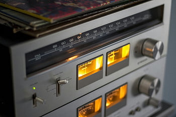 retro audio equipment, illuminated dials, radio tuner, close-up, vintage electronics, AM radio, illuminated controls, audio device, retro technology, close-up photography, vintage radio