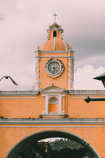 oranžová budova kostela, žlutá hodinová věž, antigua guatemala, koloniální architektura, Ikonická věž s hodinami, klasický koloniální, oranžová kopule, kostel kopule, koloniální kostel, Architektura Antiguy, Památky Guatemaly