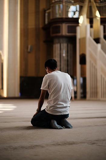 uomo che prega, interno della moschea, splendidamente decorato, In ginocchio in preghiera, ambientazione religiosa, momento spirituale, architettura islamica, posizione di preghiera, Atmosfera serena, Pratica della fede, spazio culturale