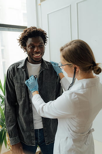 doctor, heart rate, stethoscope, smiling patient, bright room, positive medical experience, medical check-up, healthcare professional, patient care, medical examination, gloves