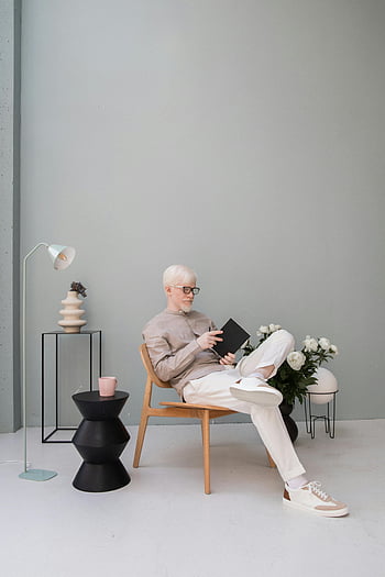 albino člověk, stylový chlap, moderní pokoj, minimalistické nastavení, čtení knihy, relaxační židle, Vnitřní nastavení, Promyšlený muž, Stylový interiér, minimalistický dekor