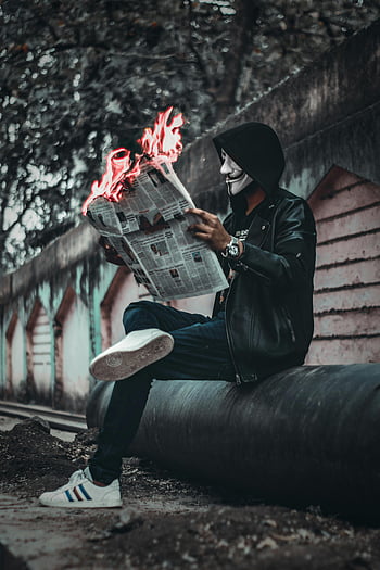 Seated Man, reading Newspaper, Flames, urban street, surreal scene, mysterious scene, mask, flaming newspaper, leather jacket, hooded figure, urban setting