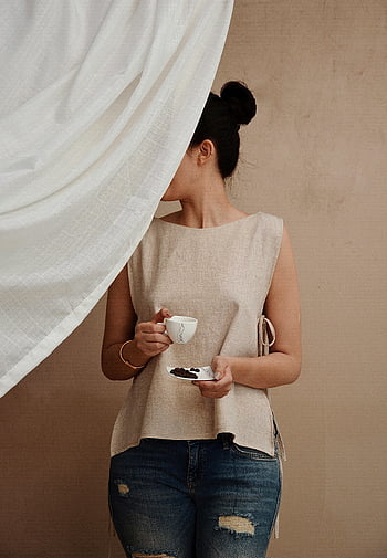 ผู้หญิงกับกาแฟ, ผู้หญิงทันสมัย, ด้านหลังม่าน, บรรยากาศผ่อนคลาย, เพลิดเพลินกับกาแฟ, ชุดลำลอง, กางเกงขาสั้นผ้ายีนส์, ด้านบนสีเบจ, การตั้งค่าในร่ม, สไตล์โมเดิร์น, ฉากหลังผ้า