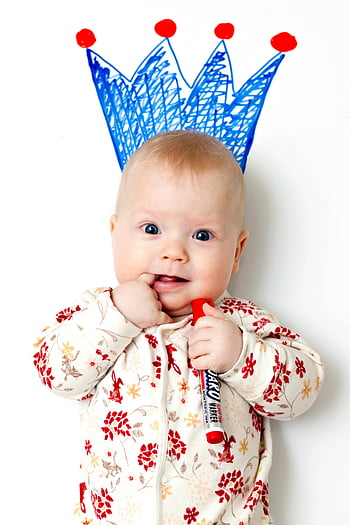 baby, white and red floral pajama, cute baby, patterned clothing, holding marker, crown drawn, joy, innocence, baby photography, baby portrait, baby art