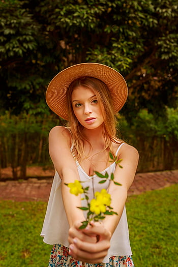 Frau, Spaghetti -Strapp -Hemd, gelbe Blumen, Strohhut, üppiger grünes Park, junge Frau, Porträt im Freien, natürliche Umgebung, Blumenkleid, Sommermode, Naturfotografie
