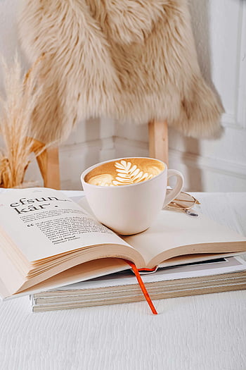 ถ้วยกาแฟ, ศิลปะลาเต้, เปิดหนังสือ, ฉากในร่ม, บรรยากาศอบอุ่น, ฉากเชิญชวน, การตั้งค่าที่สะดวกสบาย, เก้าอี้ขนสัตว์, อ่านนุ๊ก, กาแฟและหนังสือ, การออกแบบลาเต้