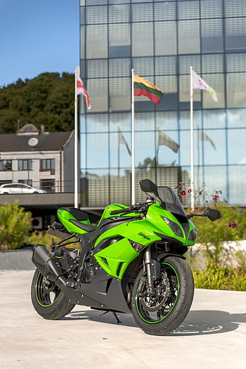grünes Motorrad, abgestelltes Motorrad, modernes Gebäude, Parkplätze im Freien, Flaggen, grünes Fahrrad, Motorrad im Freien, moderne Architektur, grünes Fahrzeug, Straßenparkplätze, Flaggen Hintergrund