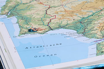 close-up photography, map, miniature figure, sunbathing, detailed geographic map, Spain's coastline, creative scene, Atlantic Ocean, miniature photography, map art, miniature art