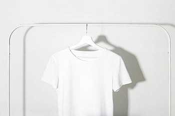 white t-shirt, hanger, minimalist backdrop, white backdrop, shadows, plain white t-shirt, minimalist design, clothing display, white rack, minimalist fashion, white shirt