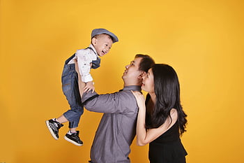 family, joyful moment, parents and child, vibrant backdrop, yellow background, happy family, family photo, family time, family bonding, family portrait, family happiness