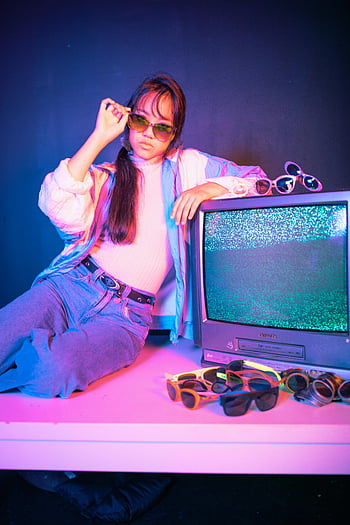 retro portré, ázsiai nő, crt tv, neon színek, Stílusos ruha, napszemüveg, vintage beállítás, 80 -as évek esztétikája, divatfotózás, beltéri jelenet, retro hangulat
