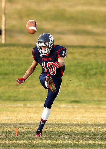 fotballspiller, spillfelt, dynamisk handling, amerikansk fotball, sparker ball, gressletter, sportsaksjon, utendørs sport, Atletisk ytelse, sport fotografering, fotball utstyr