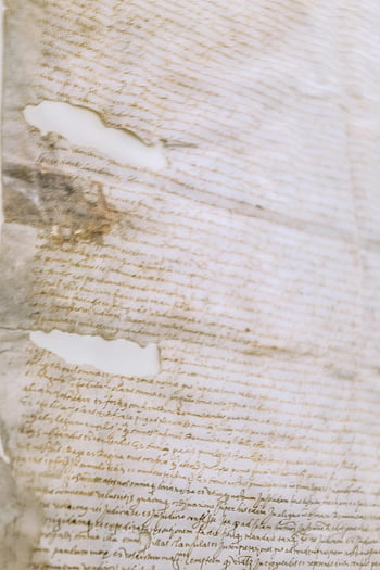 old torn paper, vintage manuscript, handwritten text, cursive calligraphy, weathered edges, textured surface, close-up, antique document, aged paper, historical writing, manuscript details