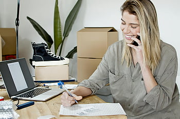 donna che prende gli ordini, Telefono, il computer portatile, gli appunti, scrivania da ufficio, negozio online, donna d'affari, multitasking, contento, Gestione degli ordini, scatole di cartone