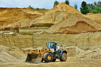 front-end loader, excavator, open pit mine, sandy terrain, clear sky, construction equipment, mining industry, heavy machinery, earthmoving equipment, industrial site, outdoor work