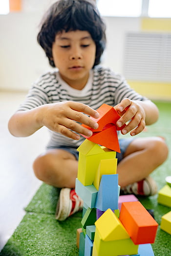 boy-white-and-black-stripe-shirt-playing-wooden-blocks-colorful-tower-classroom-setting-creativity-focus-young-child-assembling-thumbnail.jpg