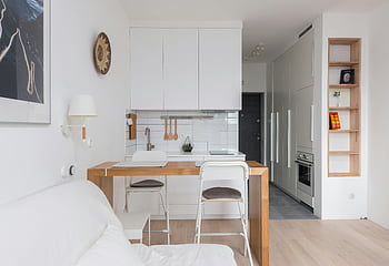 Przytulne mieszkanie, minimalistyczne wnętrze, nowoczesna kuchnia, przestrzeń życiowa, Wygodna sofa, drewniany licznik, białe szafki, Otwarty układ, współczesny design, mały apartament, przytulny salon