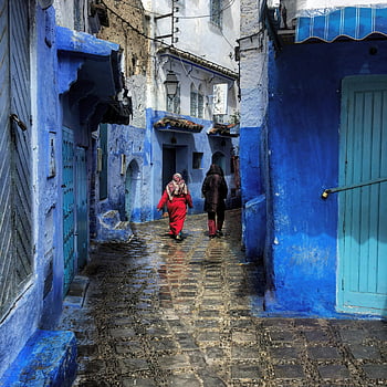 Chefchaouen, Marruecos, callejones azules, azul vibrante, Dos personas caminando, encanto único, cultura de la ciudad, calle de adoquines, edificios azules, puertas tradicionales, exploración cultural